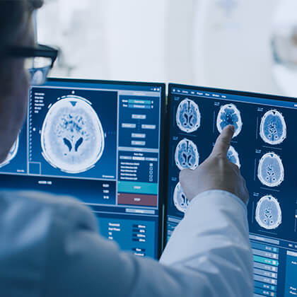 Physician pointing at image on screen from MRI