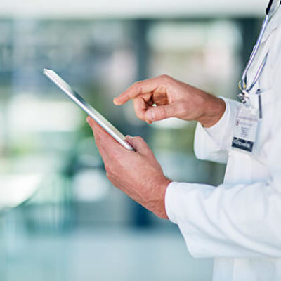 Physician about to touch tablet while walking